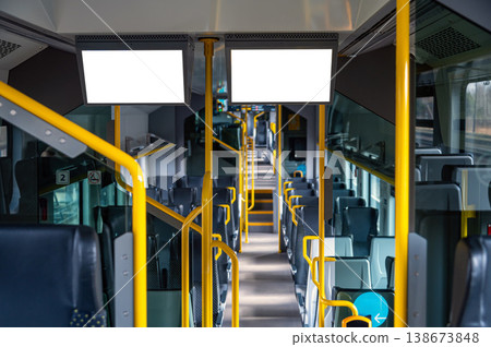 Empty bus interior shows seats and blank display panels. Space for advertisement or design. Empty bus interior shows seats and blank display panels. Space for advertisement or design. 138673848