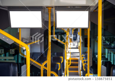 Interior of a public bus with empty seats and yellow handles visible during daylight hours Interior of a public bus with empty seats and yellow handles visible during daylight hours 138673851
