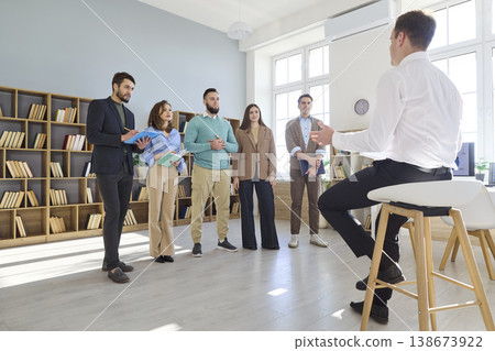 Coach leading team meeting in bright office during business training workshop Coach leading team meeting in bright office during business training workshop 138673922