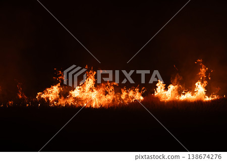 Burning fire flames isolated on dark background with smoke, dramatic wildfire effect, high contrast fire texture for overlay and design use. 138674276