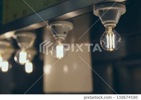 An interior design featuring rows of light bulbs; lighting fixtures arranged at equal intervals. An interior design featuring rows of light bulbs; lighting fixtures arranged at equal intervals. 138674580