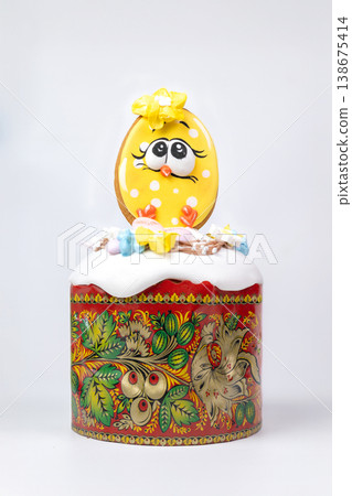 Easter Kulich in Painted Mold with Icing and Playful Gingerbread Egg Character Easter Kulich in Painted Mold with Icing and Playful Gingerbread Egg Character 138675414