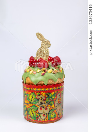 Easter Kulich in Decorated Paper Mold with Green Icing, Raspberries, Pistachios, and Golden Bunny Easter Kulich in Decorated Paper Mold with Green Icing, Raspberries, Pistachios, and Golden Bunny 138675416