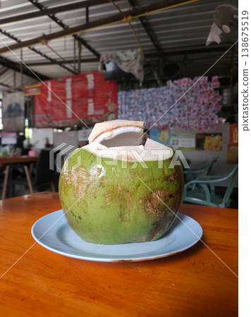 Fresh Green Young Coconut Served on a Plate in a Thai Cafe Fresh Green Young Coconut Served on a Plate in a Thai Cafe 138675519