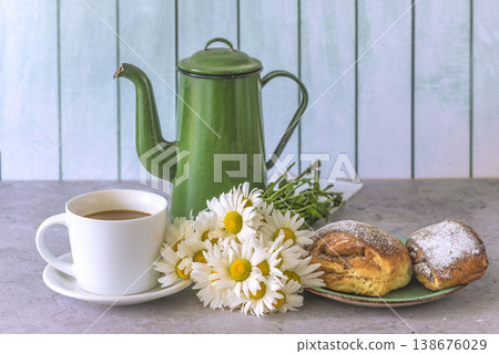 Summer breakfast with bouquet of white daisy flowers. Cup of coffee, savory pies, bunch of white daisies and vintage coffee pot on a table and wooden backgound 138676029