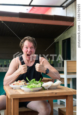 Shocked Man Giving Thumbs Up with Spicy Thai Food Som Tum Papaya Salad Expression Vertical Shocked Man Giving Thumbs Up with Spicy Thai Food Som Tum Papaya Salad Expression Vertical 138676095