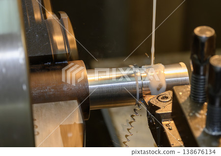 Heavy-duty lathe machine performing rough cutting on a metal shaft using an optimized liquid coolant method. Heavy-duty lathe machine performing rough cutting on a metal shaft using an optimized liquid coolant method. 138676134