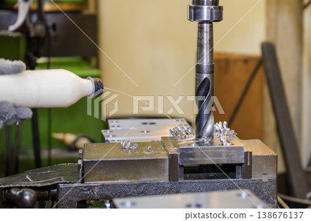 Heavy-duty hole making process on an NC milling machine using a large drill bit with manual coolant application. Heavy-duty hole making process on an NC milling machine using a large drill bit with manual coolant application. 138676137