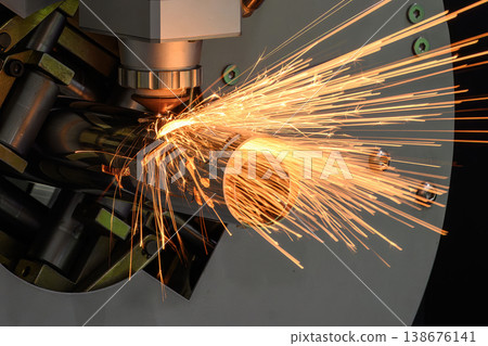 Close-up of intense sparking light from a fiber laser cutting machine processing a stainless steel pipe. Close-up of intense sparking light from a fiber laser cutting machine processing a stainless steel pipe. 138676141