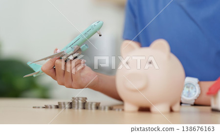 Child playing with toy airplane and piggy bank 138676163