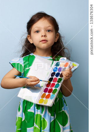 Little child girl enjoying painting with brushes and colorful watercolors Little child girl enjoying painting with brushes and colorful watercolors 138676304