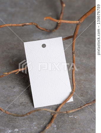Blank gift tag mockup on grey stone with dry branches, copy space. Handmade product label 138676789