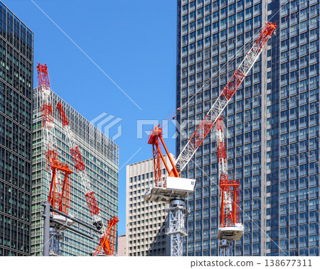 Cranes at construction sites in business districts Cranes at construction sites in business districts 138677311