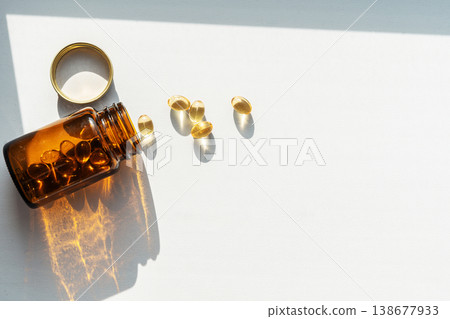 Glass dark bottle spilling vitamin pills, symbolizing daily health and wellness supplements, enhancing personal healthcare. Pills spilling from bottle for health treatments 138677933