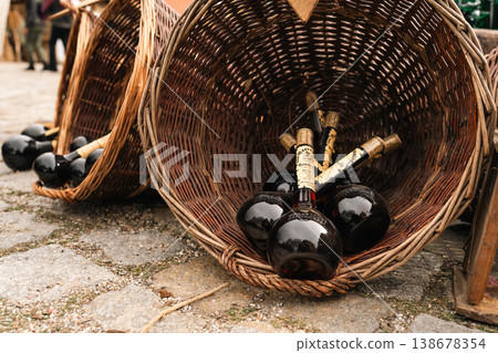 Dark bottles in wicker basket at festival market stall in Berlin 138678354