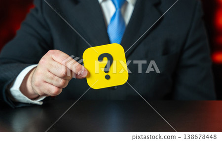 A businessman holds a question mark in his hands. Looking for an answer. Search and analysis 138678448