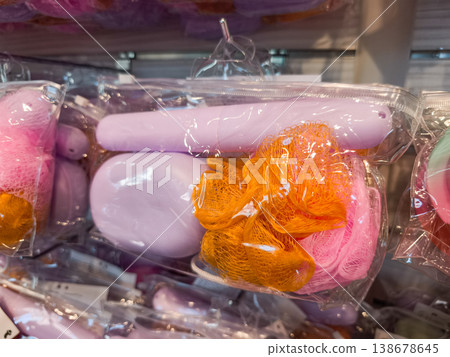 Colorful bath sponges and accessories hanging in plastic packaging, promoting hygiene and body care Colorful bath sponges and accessories hanging in plastic packaging, promoting hygiene and body care 138678645