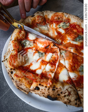 Delicious pizza being sliced with scissors on a plate showcasing melted cheese and toppings concept. copy space Delicious pizza being sliced with scissors on a plate showcasing melted cheese and toppings concept. copy space 138678690