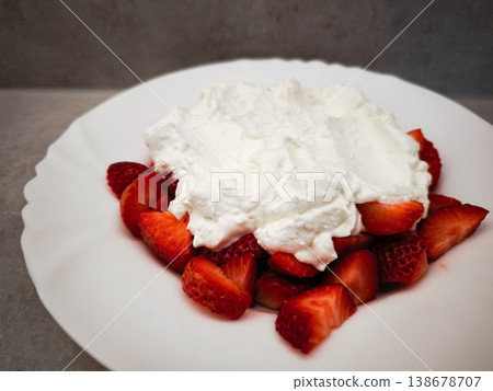 Fresh strawberries topped with creamy whipped cream dessert on a white plate delicious treat concept. copy space Fresh strawberries topped with creamy whipped cream dessert on a white plate delicious treat concept. copy space 138678707