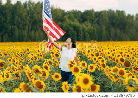 Young woman with American flag in the sunflower field. 4th of July Independence Day USA concept Young woman with American flag in the sunflower field. 4th of July Independence Day USA concept 138679790