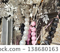 Pink, white, and black beads with leaves hang as decor near the entrance to the boutique 138680163