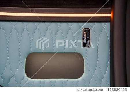 Close up of light blue quilted leather car door panel with integrated usb charging ports and ambient lighting. Close up of light blue quilted leather car door panel with integrated usb charging ports and ambient lighting. 138680433