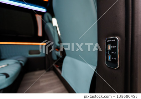 Close up of integrated USB power charging ports on dark interior panel of modern luxury vehicle Close up of integrated USB power charging ports on dark interior panel of modern luxury vehicle 138680453