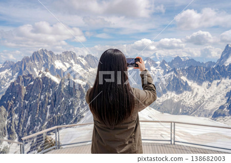 一位女士正在拍攝令人嘆為觀止的雪山美景。 一位女士正在拍攝令人嘆為觀止的雪山美景。 138682003
