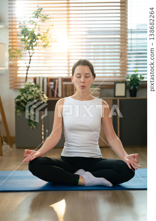 Young woman meditating on a mat at home 138682264