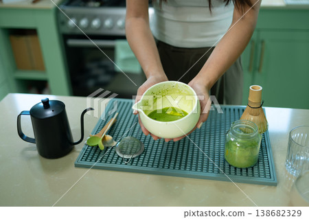 Cropped shot Woman holding bowl of freshly whisked matcha tea 138682329