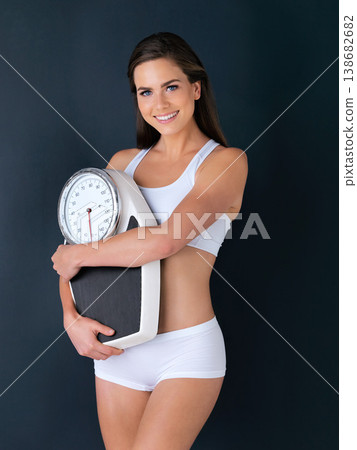 Happy woman, portrait and scale to lose weight, diet or fitness for health and wellness against a studio background. Female person or model smile with weighing machine in healthy body on mockup space Happy woman, portrait and scale to lose weight, diet or fitness for health and wellness against a studio background. Female person or model smile with weighing machine in healthy body on mockup space 138682682