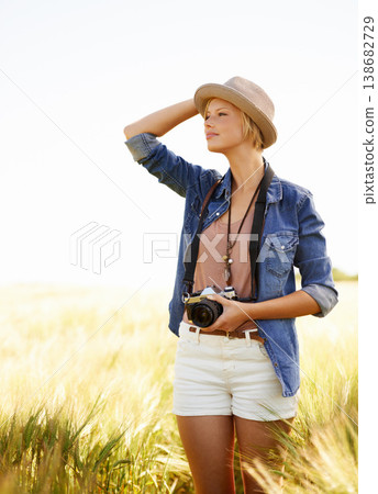 Field, photographer and woman with a camera, ideas and thinking with nature, travel and memory. Person, countryside and girl with photography, outdoor and journey with sunshine, vacation or adventure 138682729