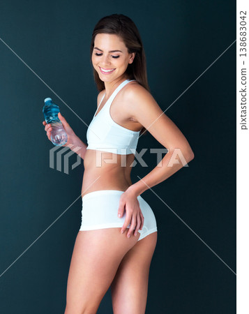 Happy woman, water bottle and bum for body diet, health and wellness against a studio background. Female person or attractive model smile posing in underwear showing off glutes, buttocks and fitness 138683042