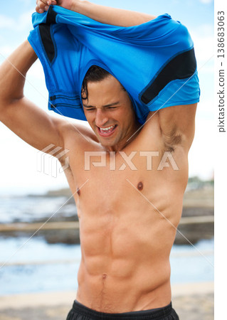 Man, fitness and remove tshirt, abs and wellness with runner outdoor, cardio and break after workout. Body, tired and training for health, stomach muscle and bodybuilding with sports athlete at beach Man, fitness and remove tshirt, abs and wellness with runner outdoor, cardio and break after workout. Body, tired and training for health, stomach muscle and bodybuilding with sports athlete at beach 138683063