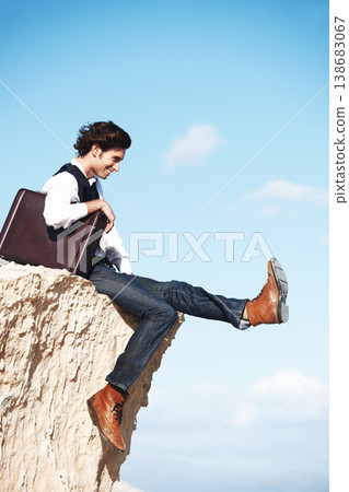 Businessman, thinking and sitting on cliff with smile for freedom by looking at sky with briefcase. Young person, happiness and excited for startup career with leg kick with mockup for new idea Businessman, thinking and sitting on cliff with smile for freedom by looking at sky with briefcase. Young person, happiness and excited for startup career with leg kick with mockup for new idea 138683067