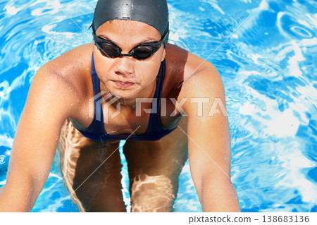 Woman, athlete and swimming in pool of blue water for challenge, sports and training from above. Professional swimmer with goggles for performance, exercise and triathlon competition, contest or race 138683136