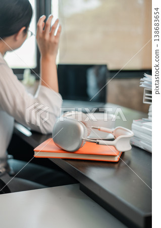 A sleek office desk with headphones, laptop, and a professional, capturing a modern work environment. 138683654