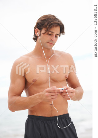Man, muscle and music on beach or exercise listening audio for sea air, playlist or running entertainment. Male person, radio and streaming song player or fresh ocean, weekend training or summer fun Man, muscle and music on beach or exercise listening audio for sea air, playlist or running entertainment. Male person, radio and streaming song player or fresh ocean, weekend training or summer fun 138683811