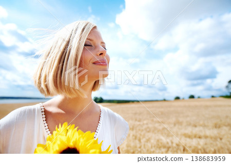Freedom, relax and calm woman with a sunflower on a wheat field for travel or vacation. Peace, face and female person in nature with a flower in nature for holiday, journey or adventure outdoor 138683959
