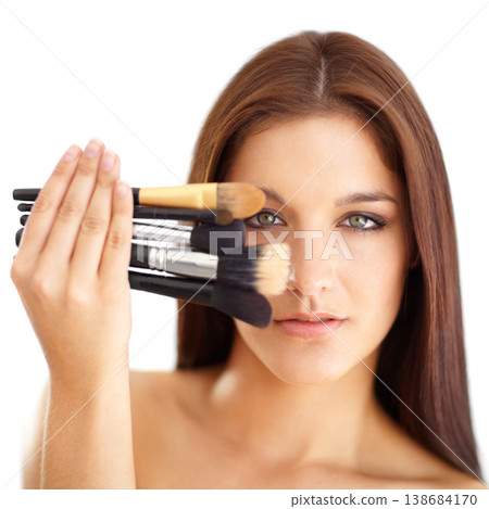 Portrait, woman and makeup with brushes in studio on white background for mockup in cosmetics. Person, hand and showing of tools for foundation, blush or contour on face for beauty treatment in salon Portrait, woman and makeup with brushes in studio on white background for mockup in cosmetics. Person, hand and showing of tools for foundation, blush or contour on face for beauty treatment in salon 138684170