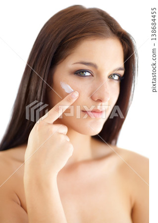 Portrait, woman and apply of moisturiser in studio in skincare cosmetic on white background. Model, person and lotion for anti-aging results, hydration or vitamin c in pigmentation or collagen boost 138684455