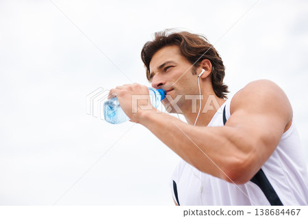 Man, drinking water on break from workout, thirsty and listening to music, podcast or song on run. Male athlete, earphones and hydrated for exercise, cardio and fitness on white background in mockup Man, drinking water on break from workout, thirsty and listening to music, podcast or song on run. Male athlete, earphones and hydrated for exercise, cardio and fitness on white background in mockup 138684467