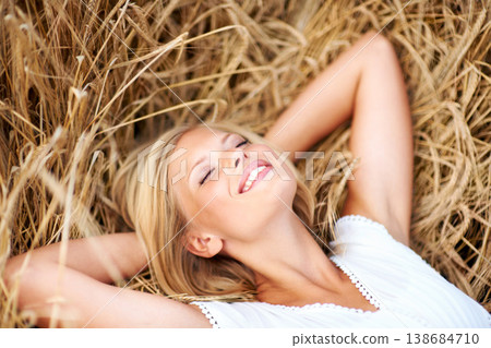 Happy woman, relax and lying on a wheat field with freedom, peace and positivity in nature. Face, smile and female person resting on grass in the countryside for vacation, trip or travel adventure 138684710