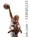 Basketball. Dynamic close-up of a basketball player in mid-air attempting a shot at the hoop during a game. Isolated 138685233