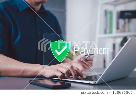 Secure Payment and Trusted Transaction Concept. A man using a laptop and smartphone with payment shield icon representing secure checkout, digital transaction protection and trusted online payment. Secure Payment and Trusted Transaction Concept. A man using a laptop and smartphone with payment shield icon representing secure checkout, digital transaction protection and trusted online payment. 138685865