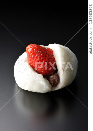 Strawberry daifuku photographed alone against a black background. Strawberry daifuku photographed alone against a black background. 138685898