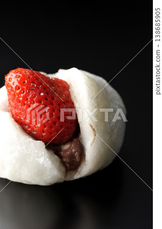 Strawberry daifuku photographed alone against a black background. Strawberry daifuku photographed alone against a black background. 138685905