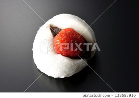 Strawberry daifuku photographed alone against a black background. Strawberry daifuku photographed alone against a black background. 138685910