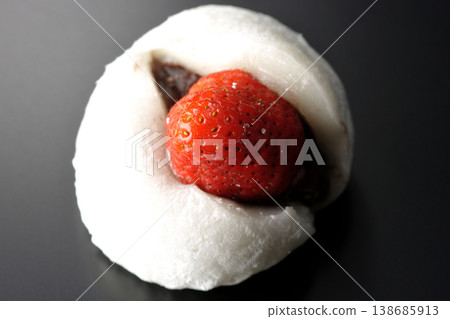 Strawberry daifuku photographed alone against a black background. Strawberry daifuku photographed alone against a black background. 138685913