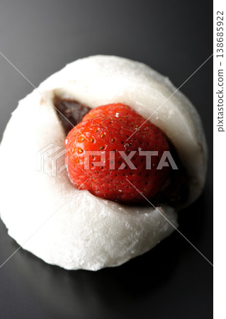 Strawberry daifuku photographed alone against a black background. Strawberry daifuku photographed alone against a black background. 138685922